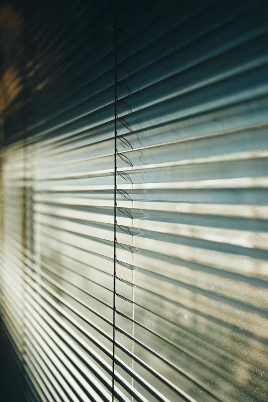 the light shines through the blinds of a house