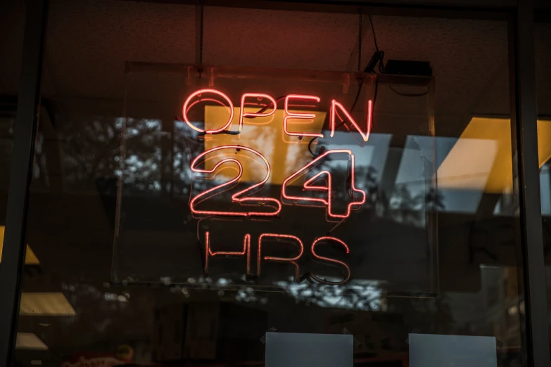 open sign in a shop window showing the hours for business