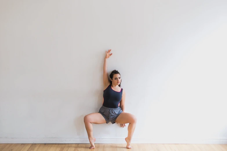 woman leaning up on wall while doing a side stand