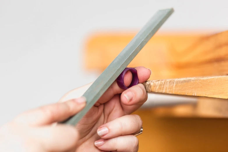 woman holding a knife and  up a piece of wood