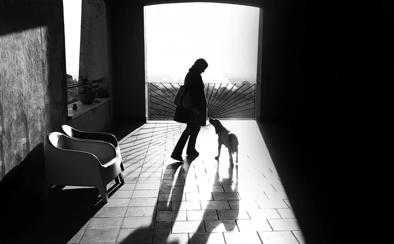 a black and white po of a person walking his dog