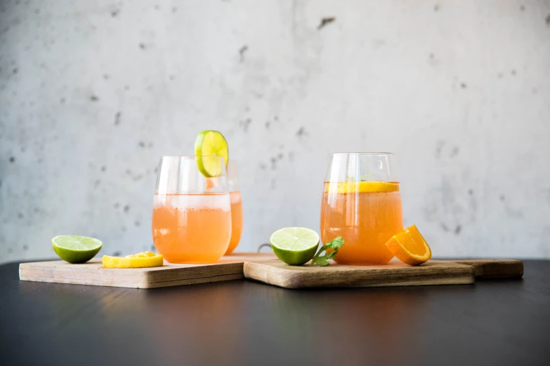 orange soda drinks garnished with lime and placed on wooden serving trays