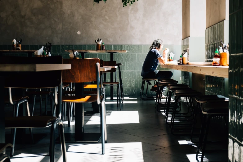 an empty restaurant with many tables with chairs and bottles of alcohol on them