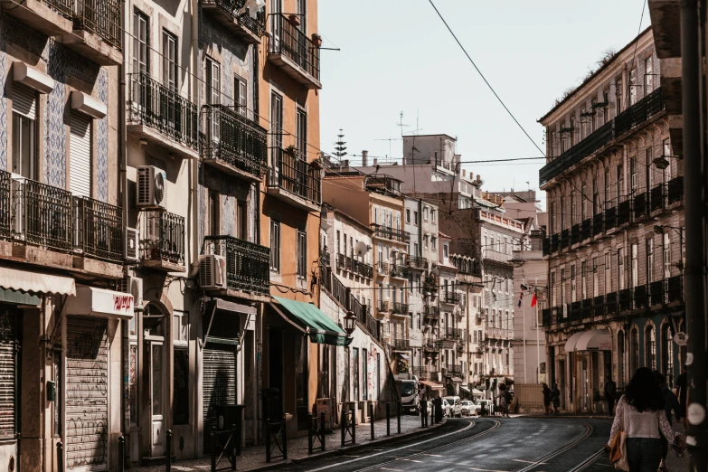 people are walking down a street next to a tall building