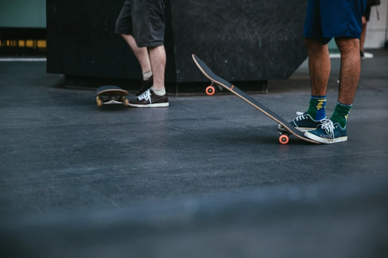 two men who are standing next to skateboards