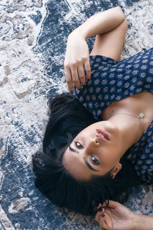 the woman lies down on the ground with a serious look on her face