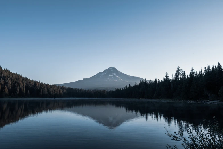 a lake surrounded by trees and tall mountains