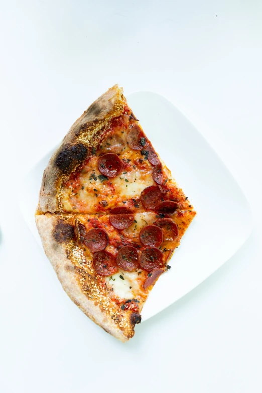 a white square plate with a slice of pizza on it