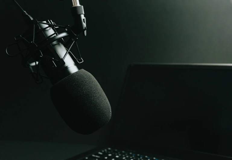 a microphone is on the desk next to a laptop
