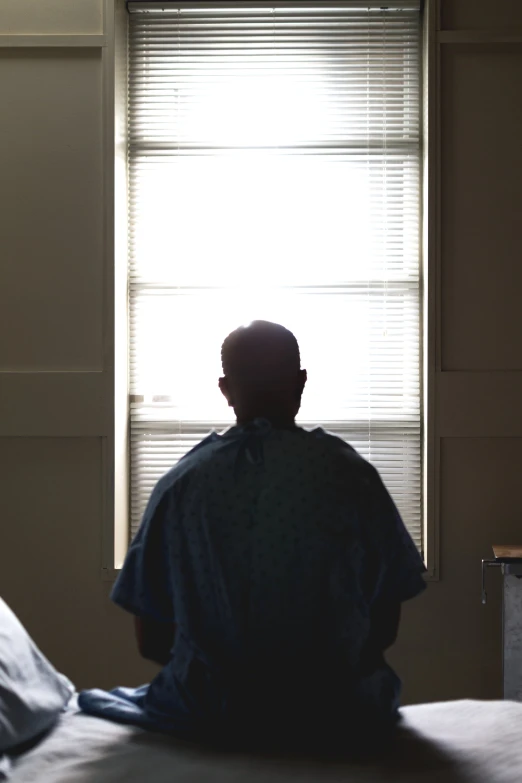 a man who is sitting down and looking out a window