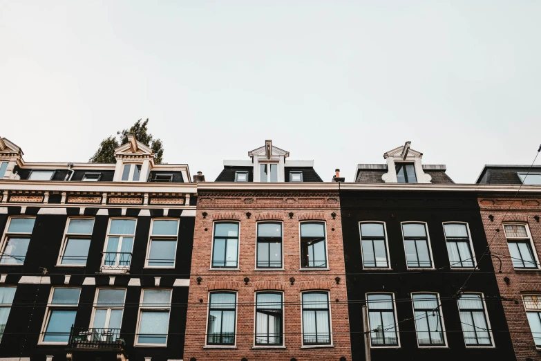 a very tall brick building surrounded by tall buildings