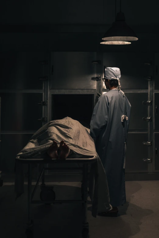 a woman standing near the hospital bed with a person laying down on it