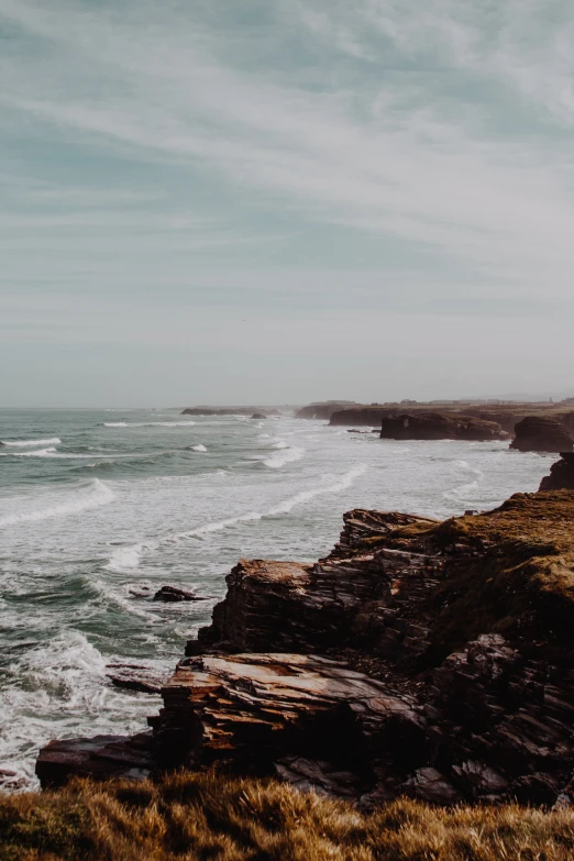 some rocky cliffs and the ocean on a clear day