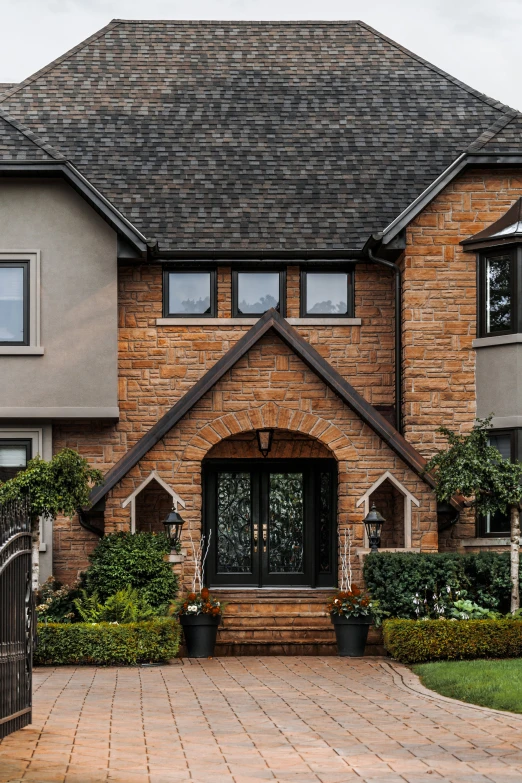 a large brick house with bushes on each side of it