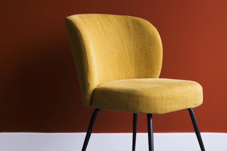 a yellow chair is placed next to a red wall