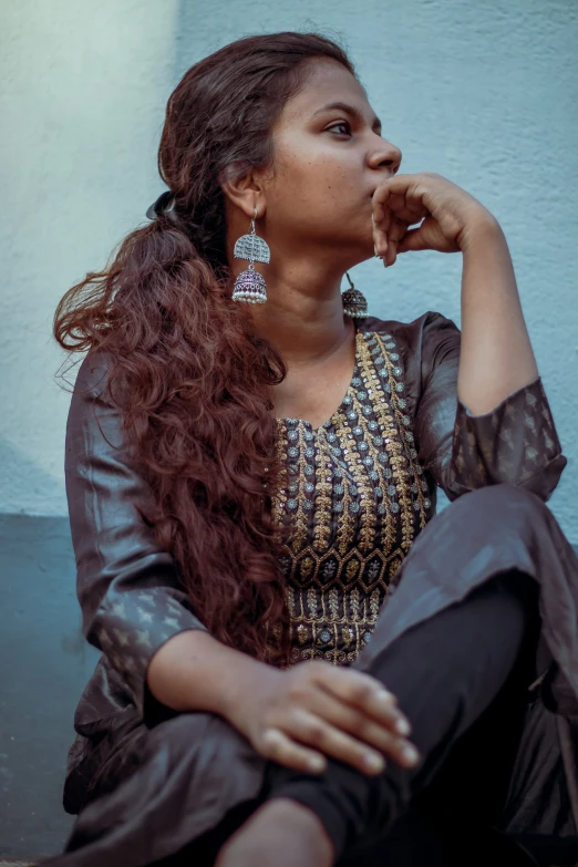 a woman wearing large earrings is posing for a picture