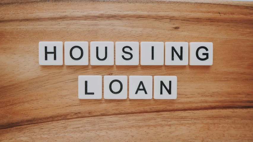 a wooden table with a block spelling housing loan