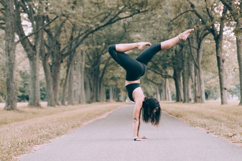 a woman doing a handstand in a park