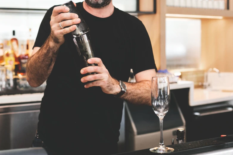 a man at a bar making an alcoholic drink