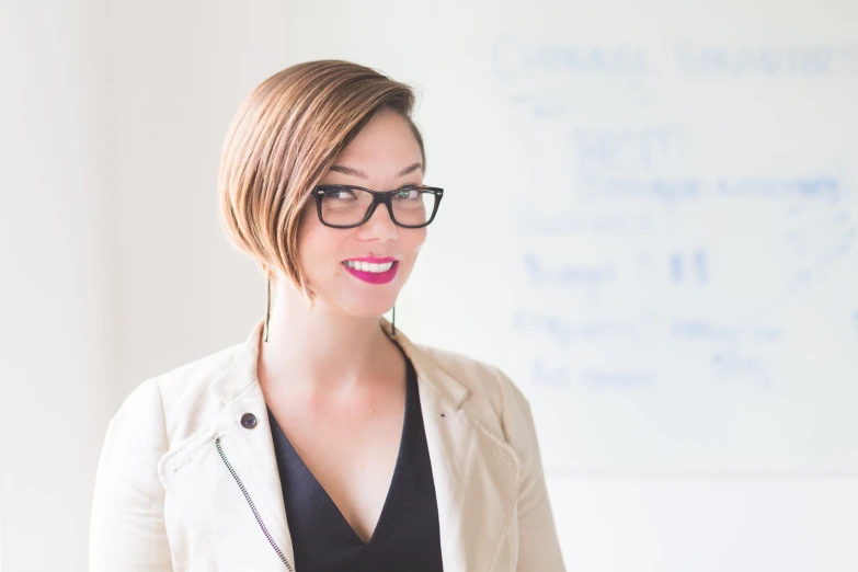 a woman in glasses looking at the camera