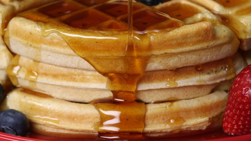 a stack of pancakes with syrup dripping down the middle