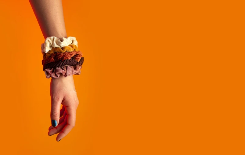 a woman holding her hand down on an orange background