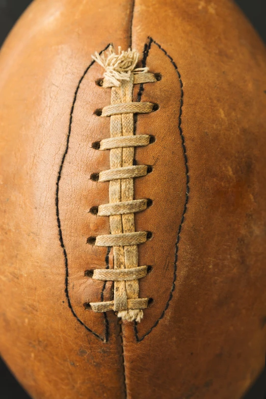 an antique brown football with a stitch on the inside