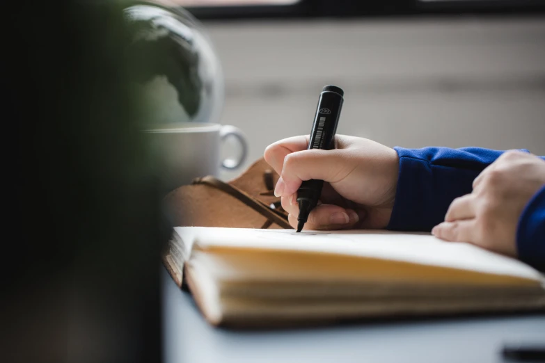 person using a small fountain pen on paper