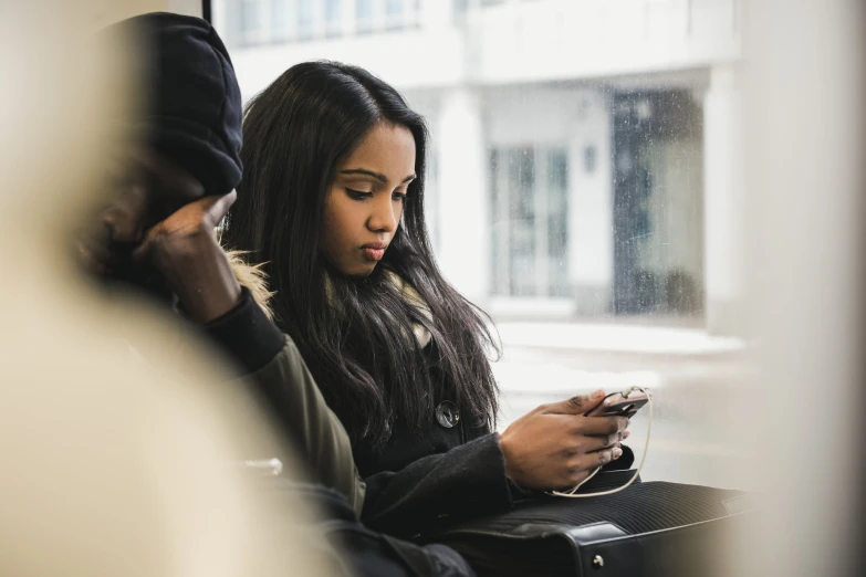 a woman sitting down and checking her cell phone