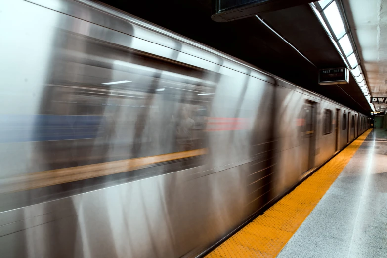 blurry train with a subway platform and light