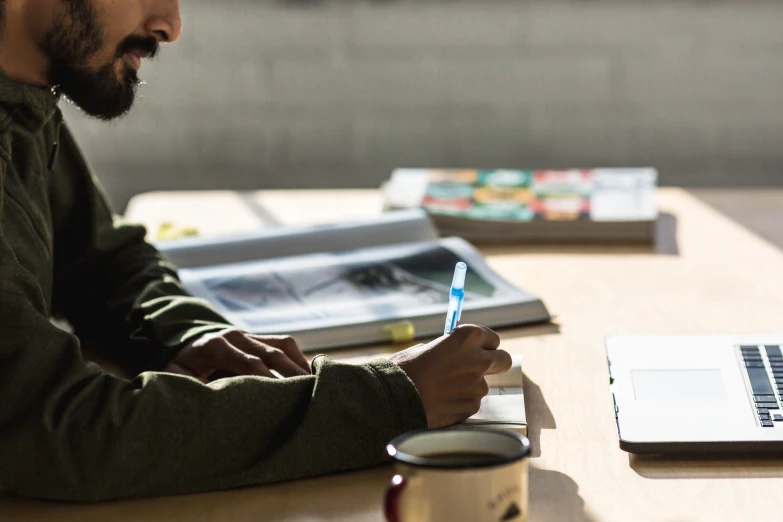 a man sitting at a table working on his laptop