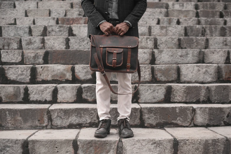 a man is standing with a brown briefcase