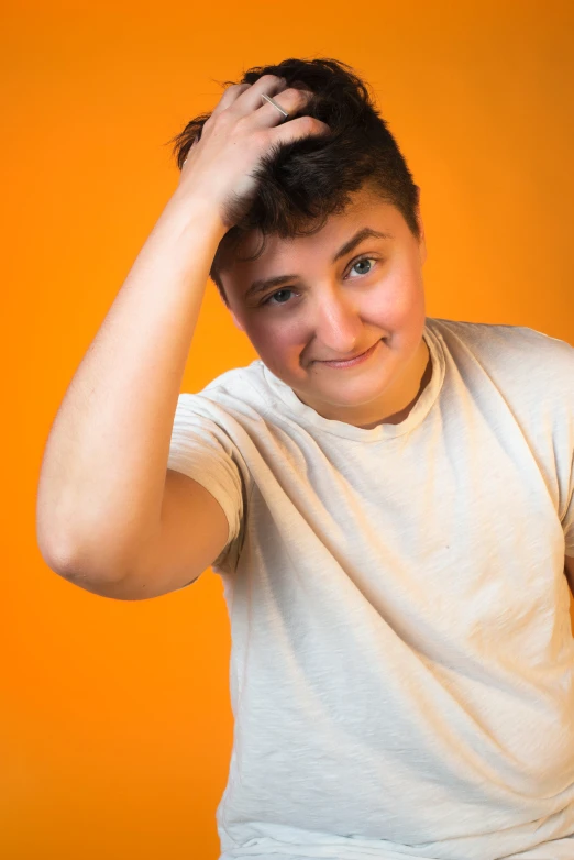 young man is holding his hair to his side