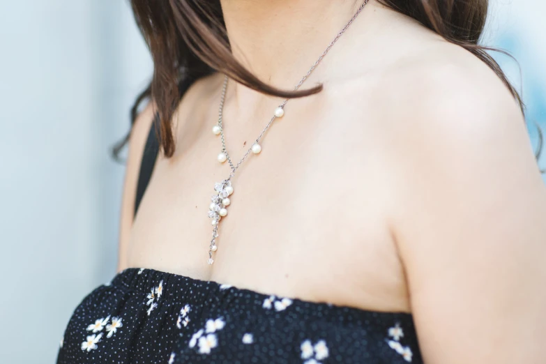 a woman in a black and white top has some silver beads