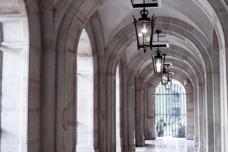 the hallway is lined with tall arches and lamps