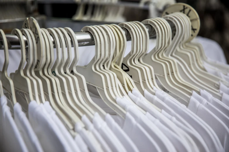 a closeup view of clothes on hangers with white sheets