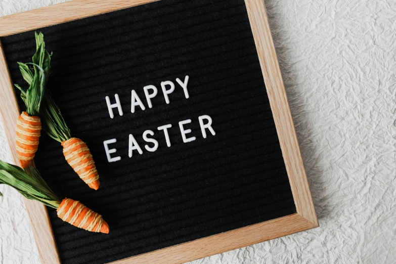 two carrots laying on top of a black board