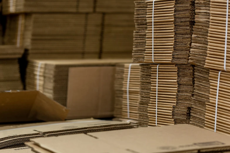 stacks of cardboard boxes sit on the ground near other cardboard boxes