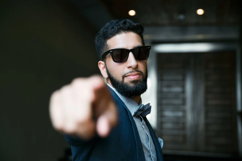 a man wearing shades and pointing towards the camera