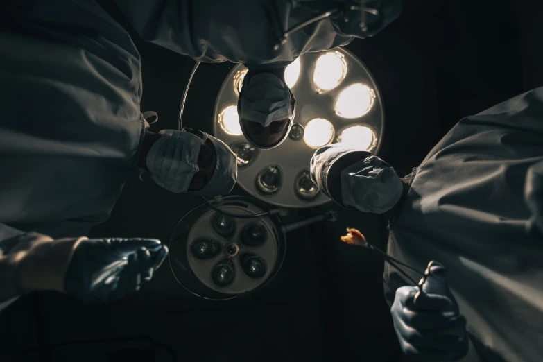 a surgeons holding lights with scissors in each hand