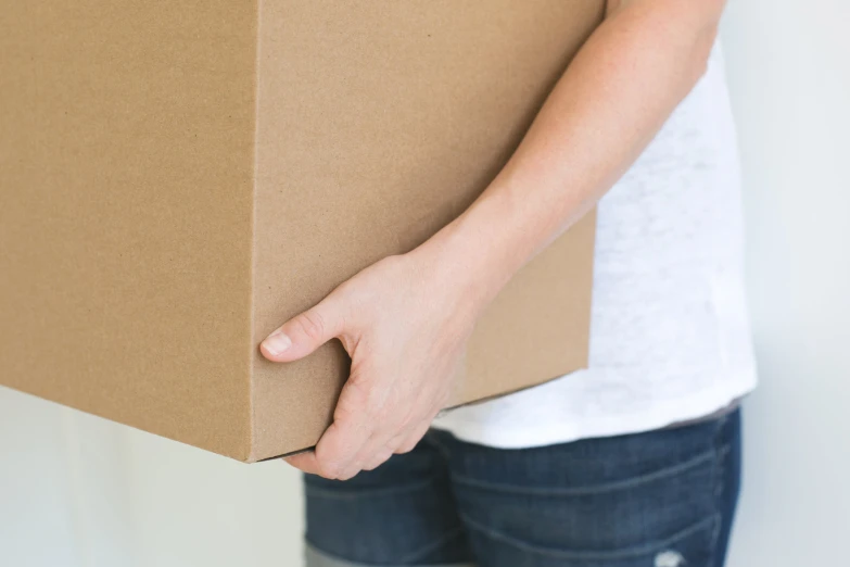 a person's hand on the end of a cardboard box