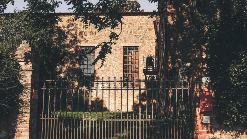 a brick building with an iron gate in front