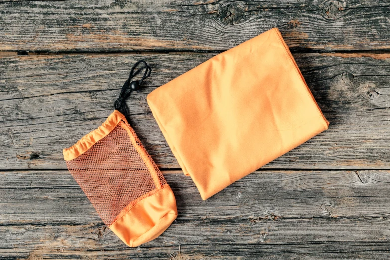 an orange cloth with an empty pouch on a wooden surface