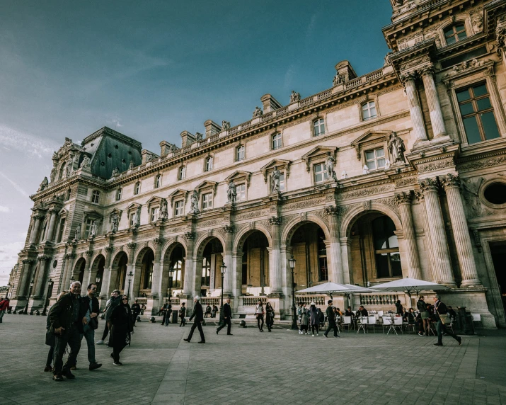 several people walking in front of a big building