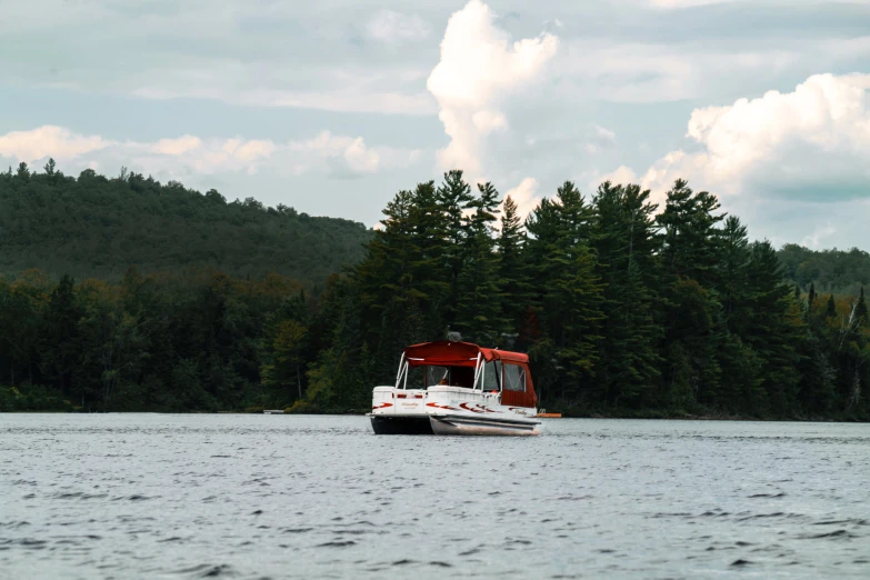 a boat is traveling through the water surrounded by wooded mountains