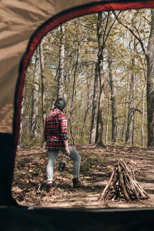 a person standing in front of some trees in the woods