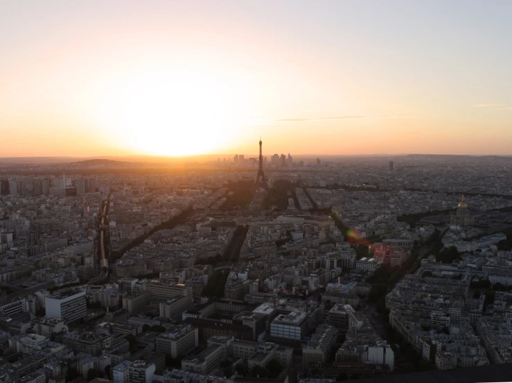 an aerial view of the sun setting over the city