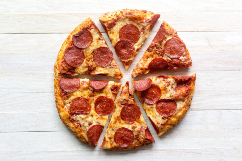 slices of pepperoni pizza laid out on a wooden table