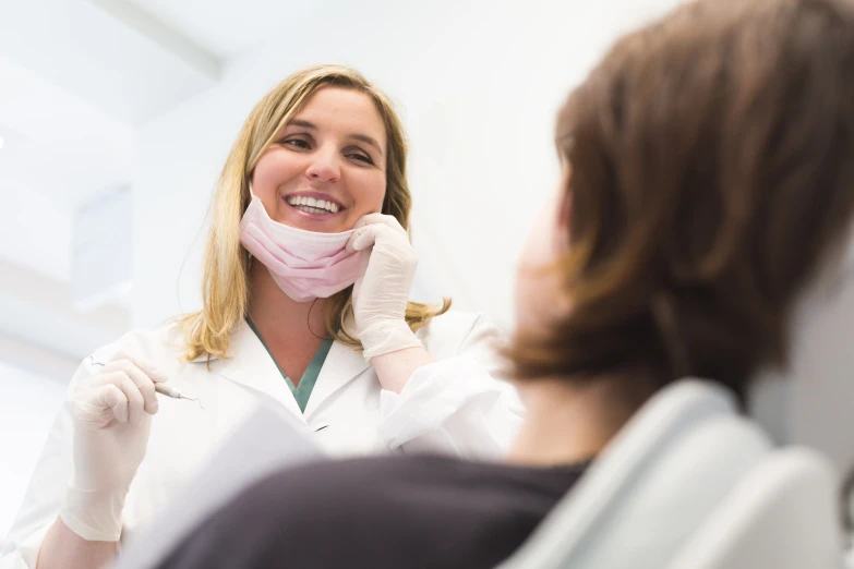 a woman smiling and having a check - up on her teeth