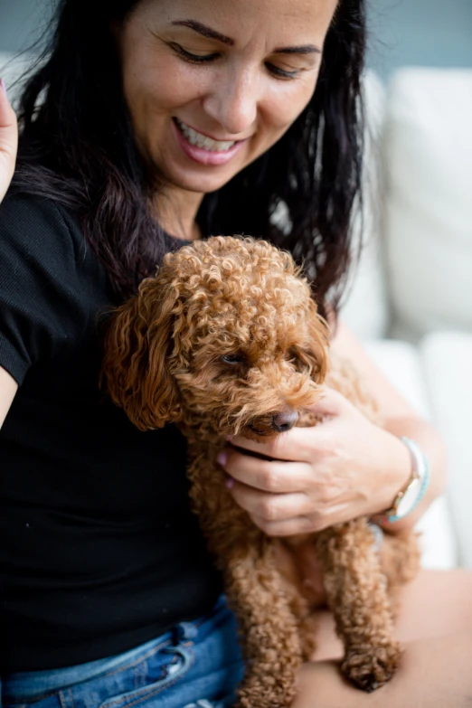 woman holding a small dog and smiling